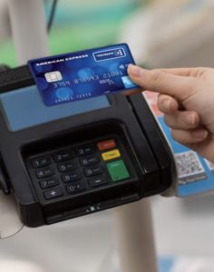 persona che avvicina carta amex payback a un pos